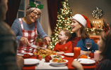 Lächelnde Seniorin serviert ihrer Familie die Weihnachtsgans 